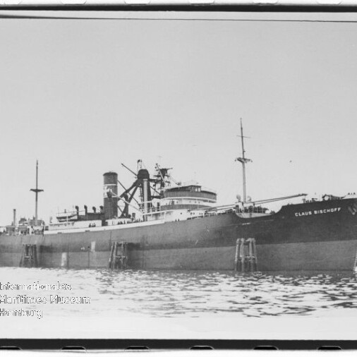 Großes Frachtschiff CLAUS BISCHOFF am Kai, mit Ladekränen und ruhigem Wasser im Vordergrund.