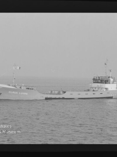 Küstenfrachtschiff mit aufgesetzter Brücke und Namen am Bug, das ruhig über die offene See fährt.