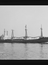 Frachtschiff mit drei Masten und Ladegeschirr auf ruhiger See; Wasserzeichen Internationales Maritimes Museum Hamburg unten