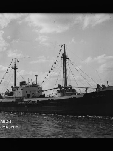 Frachtschiff mit zwei Masten und Signalwimpeln, Schriftzug 
