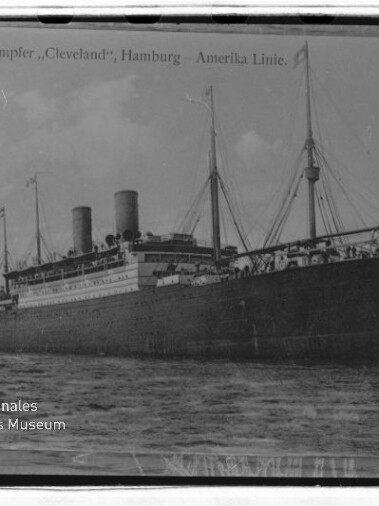 Zweischornsteiniger Passagierdampfer Cleveland der Hamburg-Amerika Linie auf ruhiger See, schwarzweißes Postkartenfoto.
