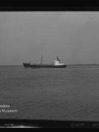 Schwarzweißfoto eines Frachtschiffs auf ruhiger See vor flachem Horizont, mit dem Schriftzug Internationales Maritimes Museum Hamburg.