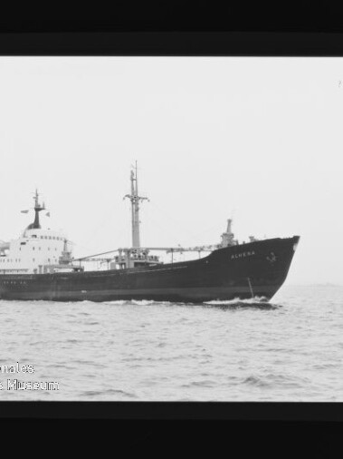 Schwarzweißfoto eines Frachtschiffs in Seitenansicht auf ruhiger See; Wasserzeichen Internationales Maritimes Museum Hamburg.