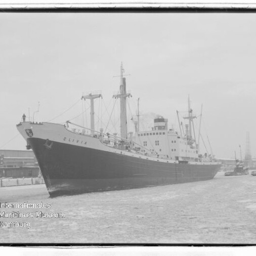 Frachtschiff Olivia längs Kai in einem Hafen, Kräne im Hintergrund und vereiste Wasseroberfläche.
