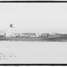 Seitenansicht eines beladenen Containerschiffs, das ruhig auf dem Meer fährt, mit übereinander gestapelten Containern und einem Museumsstempel unten links (Internationales Maritimes Museum Hamburg).