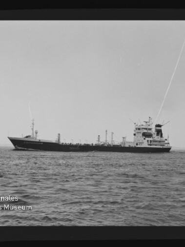Schwarzweißaufnahme eines Tankers in Seitenansicht auf ruhiger See mit weitem Horizont, sichtbarem Filmbandrand und Museumswasserzeichen unten links.