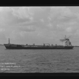 Schwarzweiß-Aufnahme eines seitlich dargestellten Tankschiffs mit dem Namen CONGER auf ruhiger See vor bewölktem Himmel; am Bildrand sind Negativkanten (AGFA APX 100) und ein Wasserzeichen des Internationalen Maritimen Museums Hamburg zu sehen.