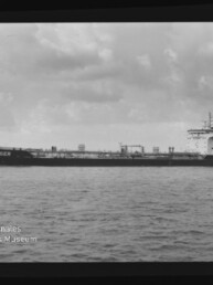 Schwarzweiß-Seitenaufnahme eines Frachttankers mit dem Namen CONGER, der ruhig auf dem Meer unter einem bewölkten Himmel fährt; Filmrand und Wasserzeichen des Internationalen Maritimen Museums Hamburg sind sichtbar.