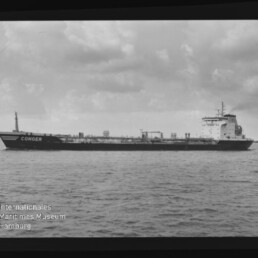Schwarzweiß-Seitenaufnahme eines Frachttankers mit dem Namen CONGER, der ruhig auf dem Meer unter einem bewölkten Himmel fährt; Filmrand und Wasserzeichen des Internationalen Maritimen Museums Hamburg sind sichtbar.