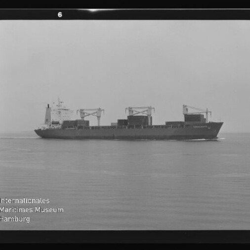 Schwarzweiß-Fotografie eines Containerschiffs in Seitenansicht auf ruhiger See, mit drei Ladekränen und Containerstapeln auf dem Deck und dem Logo des Internationalen Maritimen Museums Hamburg unten links.