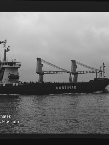 Schwarzweiß-Foto eines Frachtschiffs mit der Aufschrift CONTIMAR, das in ruhiger See unter bewölktem Himmel von der Steuerbordseite zu sehen ist; zwei große Ladekräne auf dem Deck und das Logo des Internationalen Maritimen Museums Hamburg unten links.