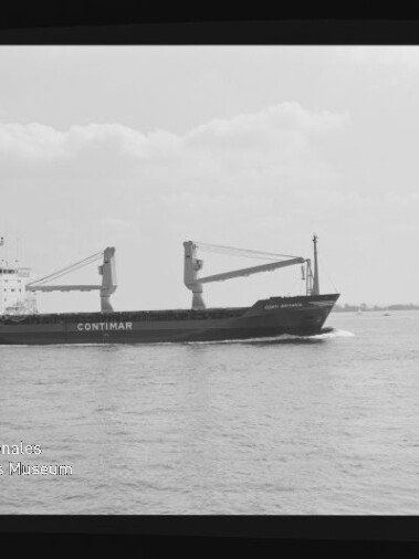 Schwarzweiß-Fotografie eines Frachtschiffs mit großem Schriftzug CONTIMAR und zwei Ladekränen auf dem Deck, das bei ruhiger See unter leicht bewölktem Himmel entlangfährt; Negativrand des Films und Wasserzeichen des Internationalen Maritimen Museums Hamburg sichtbar.