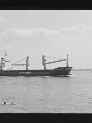 Schwarzweißaufnahme eines Frachtschiffs mit dem Schriftzug CONTIMAR und zwei Ladekränen an Deck, das über ruhige See vor flachem Horizont fährt; Filmrand und Wasserzeichen des Internationalen Maritimen Museums Hamburg sind sichtbar.