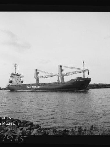 Schwarz-weiß-Foto eines Frachtschiffs mit der Aufschrift CONTIMAR und drei Ladekränen, das nahe am Ufer auf ruhigem Wasser vorbeifährt; Filmrandangaben und das Logo des Internationalen Maritimen Museums Hamburg sind sichtbar.