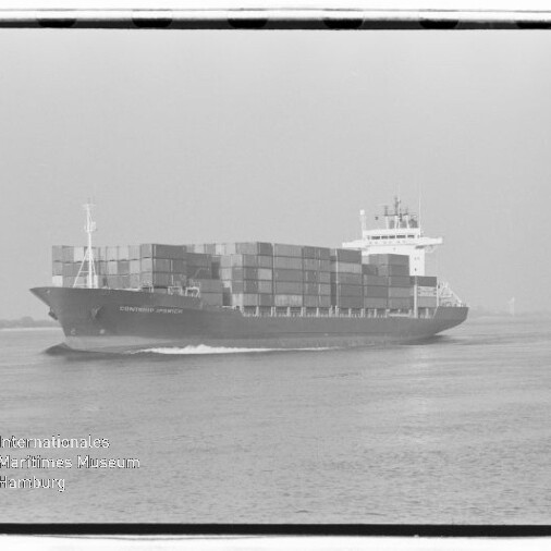 Schwarzweißaufnahme eines beladenen Containerschiffs mit mehreren Reihen hoch gestapelter Container, das ruhig auf dem Wasser fährt; unten links eingeblendetes Logo und Schriftzug des Internationalen Maritimen Museums Hamburg.
