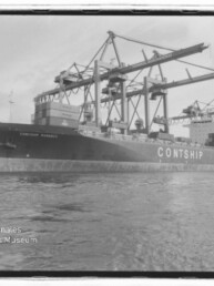 Großes Frachtschiff mit der Aufschrift CONTSHIP liegt am Kai unter mehreren Containerkränen, aufgenommen in Schwarzweiß mit Wasser im Vordergrund und einem Museumslogo unten links.