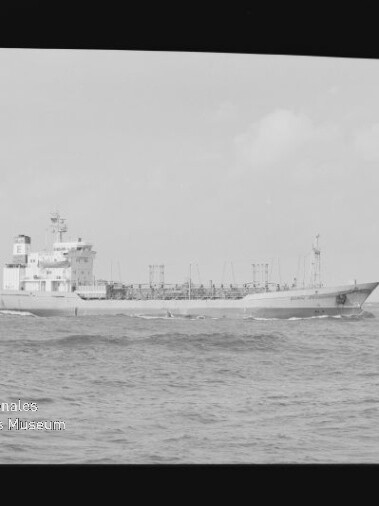 Schwarzweißaufnahme eines Frachtschiffs (Tankers) mit achterlichem Aufbauten und mehreren Decksmasten, das auf leicht gewellter See fährt; Negativrahmen mit Filmkantenmarkierungen und ein Wasserzeichen des Internationalen Maritimen Museums Hamburg unten links sichtbar.