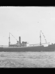 Schwarzweiß-Seitenansicht eines historischen Dampfschiffs mit mittigem Schornstein und beflaggten Masten auf ruhiger See, links unten Wasserzeichen des Internationalen Maritimen Museums Hamburg.
