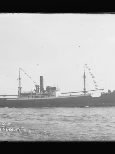 Schwarzweiß-Seitenansicht eines historischen Dampfschiffs mit mittigem Schornstein und beflaggten Masten auf ruhiger See, links unten Wasserzeichen des Internationalen Maritimen Museums Hamburg.