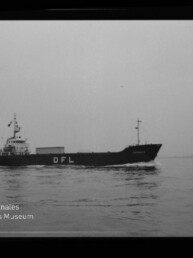 Schwarzweiß-Foto eines mittleren Frachtschiffs mit großen weißen Buchstaben „DFL“ am Rumpf, das ruhig auf ruhiger See fährt; unten links das Logo des Internationalen Maritimen Museums Hamburg und am rechten Bildrand die Beschriftung „AGFA LISS“.