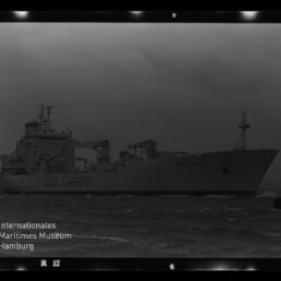 Schwarzweiß-Foto eines großen Kühlschiffs in Seitenansicht bei unruhiger See mit der Aufschrift „Cool Carriers“ auf der Bordwand; Filmrahmen und Wasserzeichen des Internationalen Maritimen Museums Hamburg unten links sichtbar.