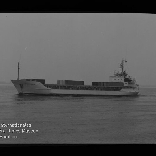 Schwarzweißaufnahme eines mittleren Containerschiffs mit mehreren Containern an Deck, das auf ruhiger See von links nach rechts fährt; links am Bildrand ein Filmstreifen mit Beschriftung und unten links Logo sowie Schriftzug des Internationalen Maritimen Museums Hamburg.