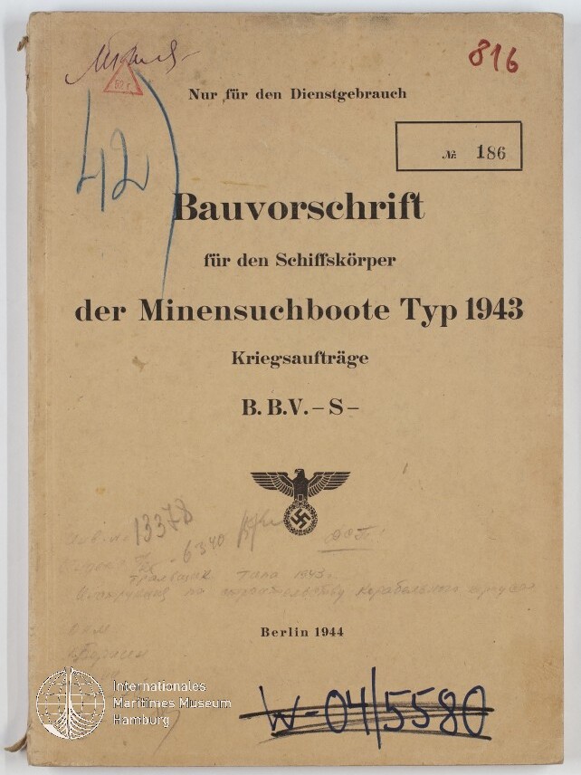 Titelblatt eines vergilbten deutschen Diensthefts »Bauvorschrift für den Schiffskörper der Minensuchboote Typ 1943« (Berlin 1944) mit gedrucktem Reichsadler über Hakenkreuz, handschriftlichen Vermerken, Stempeln, Inventarnummern und Museumssiegel in der linken unteren Ecke.