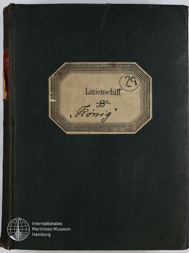 Schwarzer Buchumschlag mit aufgeklebtem oktogonalen Etikett, darauf gedruckt „Linienschiff“ und handschriftlich „S ‚König‘“ sowie eingekreistes „29“, mit rotem Reparaturstreifen am Buchrücken und weißem Museumssignet unten links.