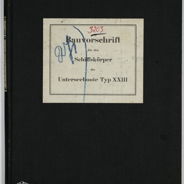 Schwarzer Leineneinband eines Buches mit mittigem, weißem Etikett, auf dem der gedruckte deutsche Titel 'Bauvorschrift für den Schiffskörper der Unterseeboote Typ XXIII' steht, übermalt mit blauer Handschrift und roter Ziffer '3203'; unten links Logo und Schriftzug des Internationalen Maritimen Museums Hamburg.