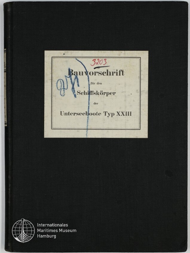 Schwarzer Leineneinband eines Buches mit mittigem, weißem Etikett, auf dem der gedruckte deutsche Titel 'Bauvorschrift für den Schiffskörper der Unterseeboote Typ XXIII' steht, übermalt mit blauer Handschrift und roter Ziffer '3203'; unten links Logo und Schriftzug des Internationalen Maritimen Museums Hamburg.