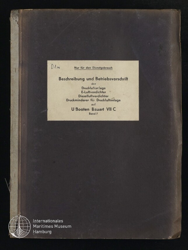 Dunkelbraunes, leicht abgenutztes Handbuch mit mittig aufgeklebt beigefarbenem Etikett mit der deutschen Überschrift «Beschreibung und Betriebsvorschrift» für die Druckluftanlage von U‑Booten Bauart VII C; unten links das Signet des Internationalen Maritimen Museums Hamburg.