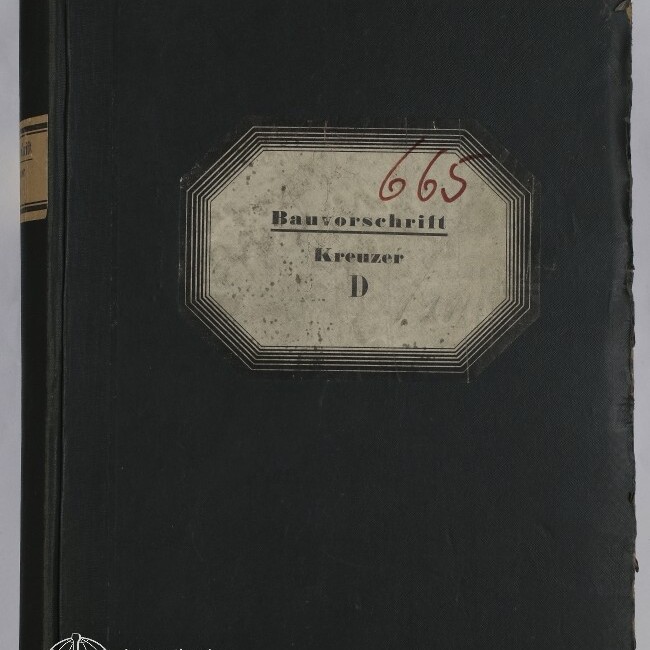 Schwarzer, abgenutzter Buchband mit cremefarbenem Etikett in der Mitte, darauf gedruckt ‚Bauvorschrift Kreuzer D‘ und handschriftliche rote Nummer ‚665‘, mit Logo des Internationalen Maritimen Museums Hamburg unten links.