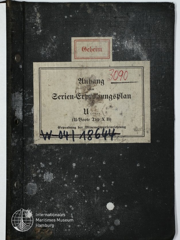Schwarzes, abgenutztes Aktenheft mit aufgeklebtem kleinen Etikett 