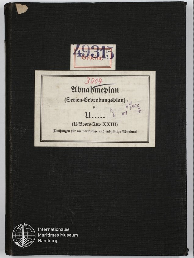 Schwarzer Buchumschlag mit weißem Etikett, auf dem der gedruckte Titel „Abnahmeplan (Serien-Erprobungsplan) für U..... (U-Boots-Typ XXIII)“ steht; Stempelnummern, handschriftliche Anmerkungen und eine rote Zahl sind auf dem Etikett, oben links ist eine leicht eingerissene Ecke und unten links das Logo des Internationalen Maritimen Museums Hamburg sichtbar.
