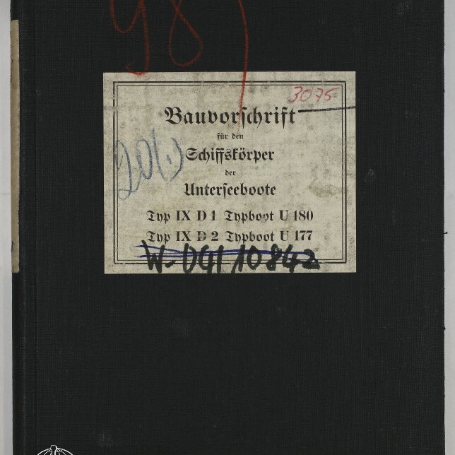 Schwarzer Leineneinband eines Buches mit einer vergilbten, mittigen Etikette in Frakturschrift Bauvorschrift für den Schiffskörper der Unterseeboote, roten und blauen Handschrift- und Stempelmarkierungen sowie dem Logo des Internationalen Maritimen Museums Hamburg unten links.