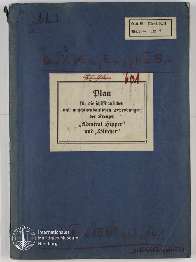 Blaues, leicht abgenutztes Heft mit aufgeklebtem weißen Etikett in der Mitte, auf dem in Frakturschrift der Titel „Plan für die schiffbaulichen und maschinenbaulichen Erprobungen der Kreuzer ‚Admiral Hipper‘ und ‚Blücher‘“ steht; Umschlag zeigt handschriftliche rote Notizen, einen kleinen Aufkleber oben rechts und ein weißes Museumssiegel unten links.