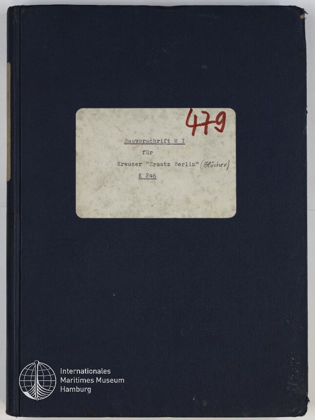 Dunkelblauer Buch- oder Ordner-Einband mit einem abgenutzten weißen Etikett, das maschinengeschriebene Aufschrift 'Bauvorschrift M I für Kreuzer 