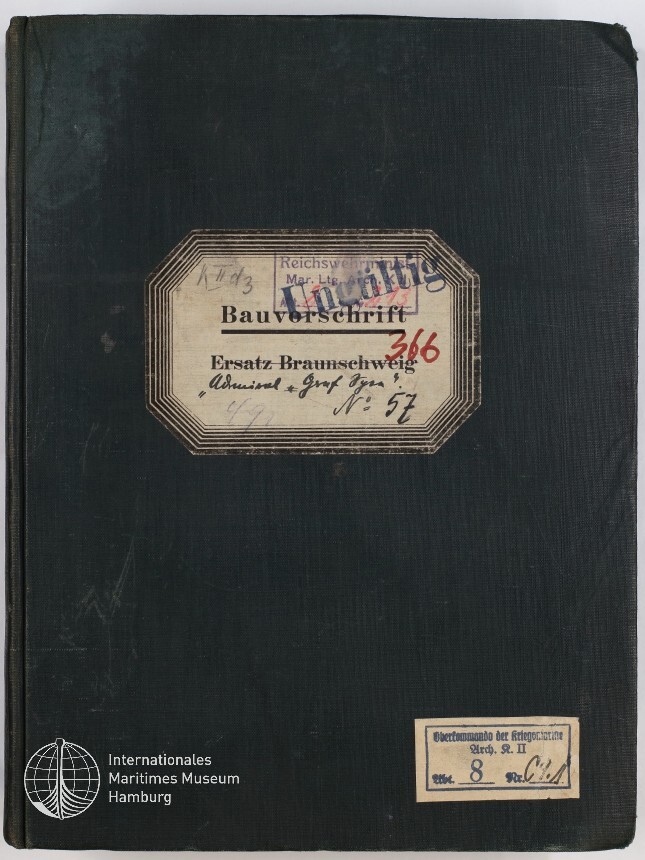 Dunkelgrünes gebundenes Heft mit einem achteckigen Etikett in der oberen Mitte, auf dem groß „Bauvorschrift“, handschriftliche Notizen, ein roter Stempel ‚366‘ und mehrere Dienststempel zu sehen sind; unten rechts ein weiterer kleiner Aufkleber und unten links das Logo des Internationalen Maritimen Museums Hamburg.