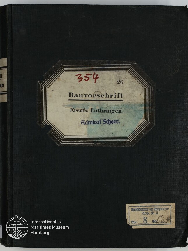 Schwarzer Leinenband eines Ordners mit großer oktogonaler Etikette in der Mitte: Aufschrift 'Bauvorschrift Ersatz Lothringen Admiral Scheer' und handschriftliche rote Zahl '354', unten rechts ein kleines gestempeltes Etikett und unten links das Logo des Internationalen Maritimen Museums Hamburg.