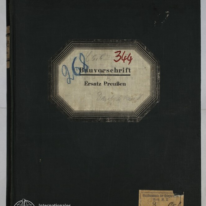 Schwarzer Leinen-Einband eines Hefts mit abgenutzten Ecken, mittig ein achteckiges Etikett mit dem gedruckten Titel Bauvorschrift Ersatz Preußen und handschriftlichen Zahlen in Blau und Rot, sowie kleinen Papieretiketten oben links und unten rechts und dem Logo des Internationalen Maritimen Museums Hamburg unten links.