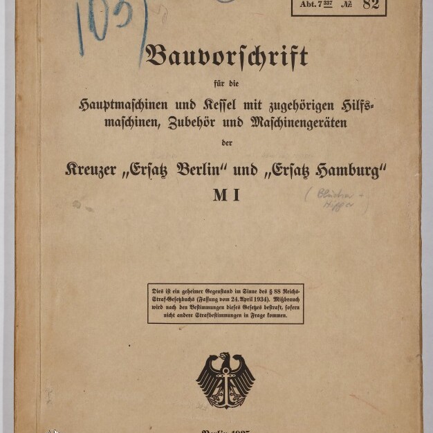 Gebräuntes Deckblatt eines technischen Handbuchs von 1935 mit dem Titel „Bauvorschrift“ für die Hauptmaschinen und Kessel der Kreuzer „Ersatz Berlin“ und „Ersatz Hamburg“ (M I), mit handschriftlichen Nummern und Stempeln, einem kleinen Aufkleber oben rechts, dem Reichsadler und dem Logostempel des Internationalen Maritimen Museums Hamburg.