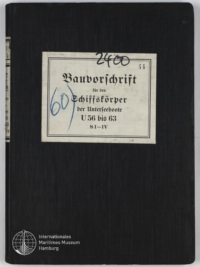 Schwarz gebundenes Buch mit zentriertem weißen Etikett, darauf in Frakturschrift der Titel ‚Bauvorschrift für den Schiffskörper der Unterseeboote U56 bis 63 S I–IV‘, handschriftliche blaue Zahl ‚60‘ und schwarze Zahl ‚2400‘ sowie kleines ‚44‘ oben rechts auf dem Etikett und weißes Museumslogo ‚Internationales Maritimes Museum Hamburg‘ unten links.