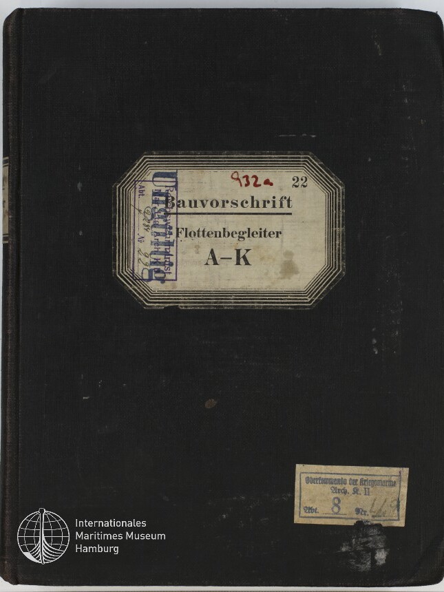 Schwarzer Leineneinband eines alten Buchs mit mittig aufgeklebtem cremefarbenem Etikett mit Rahmen und der Aufschrift „Bauvorschrift Flottenbegleiter A–K“, mehreren Stempeln und handschriftlicher roter Nummer sowie kleinem rechteckigem Stempel unten rechts und Museum-Logo unten links.