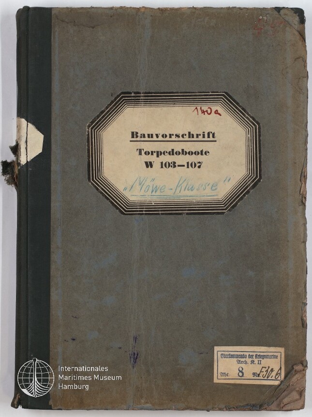 Abgenutzter graublauer Einband eines alten Bauvorschriften-Hefts mit schwarzem Leinenrücken und achteckigem Etikett: «Bauvorschrift Torpedoboote W 103–107» mit handschriftlicher Notiz «Möwe‑Klasse» und Museumswasserzeichen unten links.