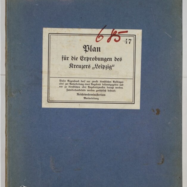 Blaues Buchcover mit einem mittig aufgeklebten weißen Etikett mit dem Titel „Plan für die Erprobungen des Kreuzers ‚Leipzig‘“, darüber rote handschriftliche Ziffern und unten links das Logo des Internationalen Maritimen Museums Hamburg.
