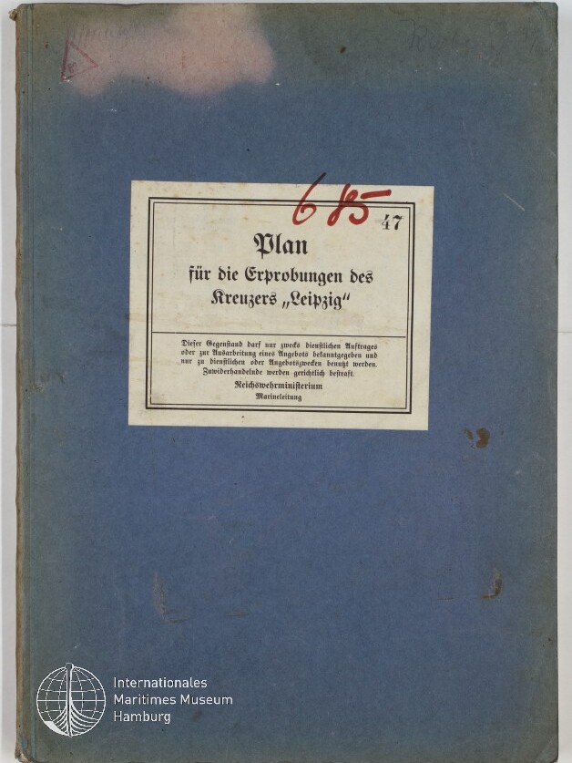 Blaues Buchcover mit einem mittig aufgeklebten weißen Etikett mit dem Titel „Plan für die Erprobungen des Kreuzers ‚Leipzig‘“, darüber rote handschriftliche Ziffern und unten links das Logo des Internationalen Maritimen Museums Hamburg.