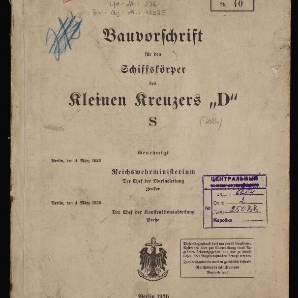 Vergilbtes Titelblatt einer deutschen Bauvorschrift für den Schiffskörper des kleinen Kreuzers „D“ S (Berlin 1926) mit handschriftlichen Notizen und Nummern, roten und lila Stempeln (kyrillischer Eingangsstempel), Reichsadler-Emblem und Museumssiegel unten links.