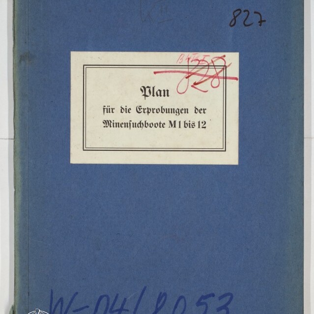 Blaue Deckmappe mit einem weißen Etikett, auf dem in Frakturschrift steht „Plan für die Erprobungen der Minensuchboote M 1 bis 12“, mit handschriftlichen Notizen, roten Streichungen und dem Logo des Internationalen Maritimen Museums Hamburg in der Ecke.