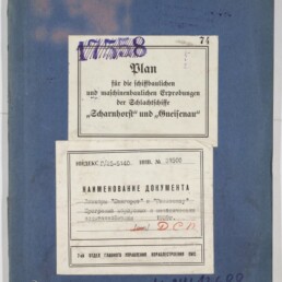 Blaues Dokumentenheft mit zwei weißen Etiketten: oben ein deutschsprachiger Titel ‚Plan für die schiffbaulichen und maschinenbaulichen Erprobungen der Schlachtschiffe „Scharnhorst“ und „Gneisenau“‘, unten ein russischer Etikettentext mit Stempeln und Inventarnummern; dazu handschriftliche Nummern und das Logo des Internationalen Maritimen Museums Hamburg unten links.