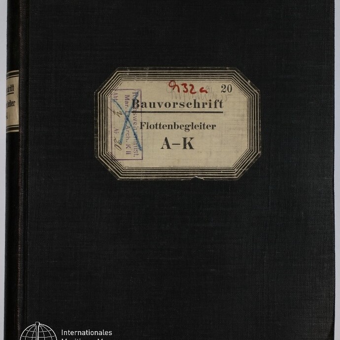 Schwarzes Leinenbuch mit mittig aufgeklebtetem cremefarbenem Etikett mit Rahmen und der Aufschrift „Bauvorschrift Flottenbegleiter A–K“, ergänzt durch rote Nummern und blauen Archivstempel, unten links das Logo des Internationalen Maritimen Museums Hamburg.